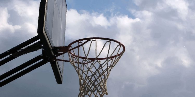 A basketball net in cloudy sunshine.